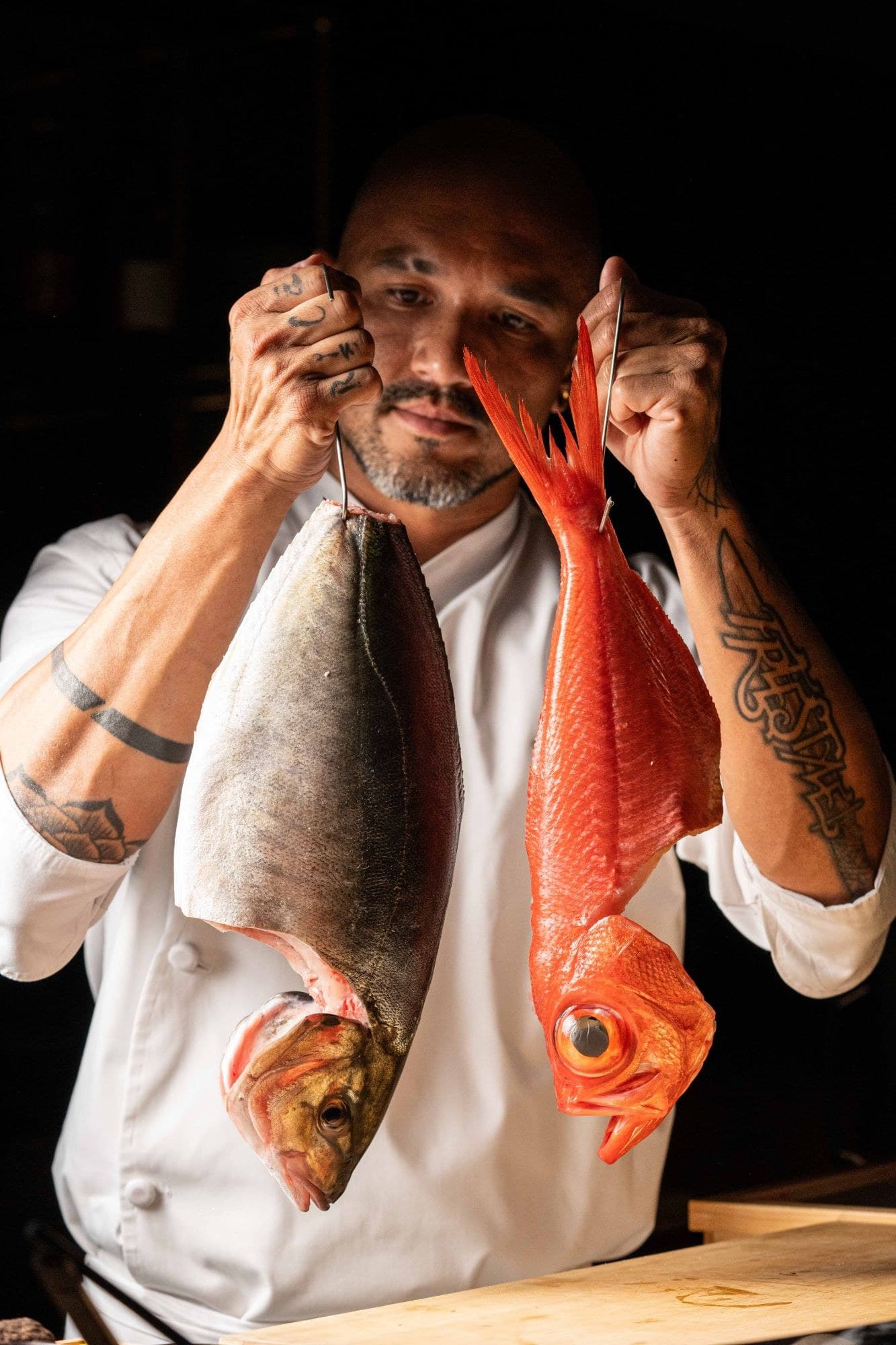 Chef Kamakura holding two whole fish sourced for the omakase